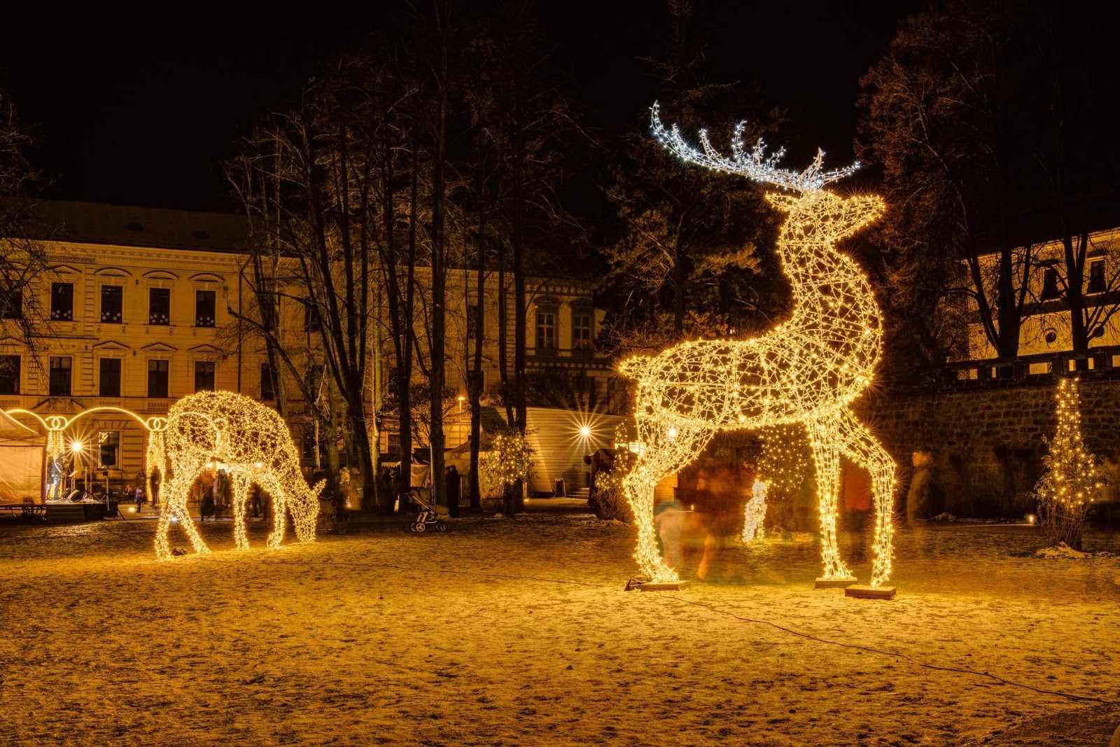 Leuchtende Hirschfiguren auf einem winterlichen Stadtplatz